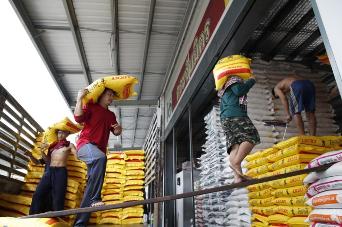 Arbeiter tragen Reissäcke zum Entladen in ein Reishandelsgeschäft auf einem Großhandelsmarkt für Reis in der Provinz Pathum Thani. Foto: epa-efe/Rungroj Yongrit