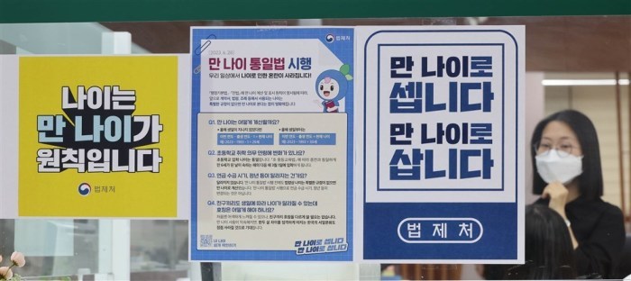 Eine Frau sieht sich eine Bekanntmachung über die Durchsetzung des Gesetzes zum neuen Alterszählungsgesetz im Songpa-gu-Büro in Seoul an.Foto: epa/Jeon Heon-kyun