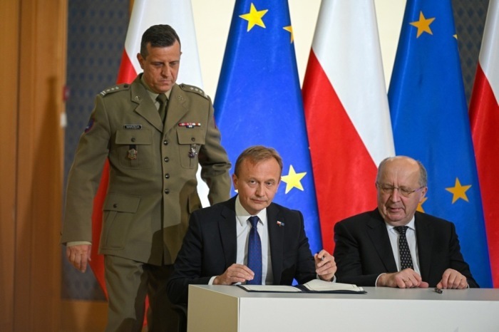 EU-Kommissar Andrius Kubilius und weitere Vertreter unterzeichnen in Warschau das SAFE-Abkommen zur Unterstützung Polens. Foto: epa/Marcin Obara