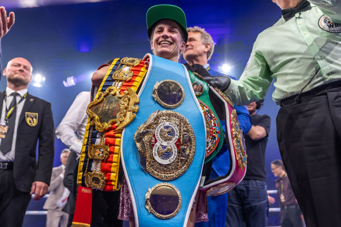 Tina Rupprecht als Undisputed Champion mit allen vier Weltmeisterschaftsgürteln der Verbände IBF, WBO, WBC und WBA. Foto: Andreas Gora/dpa