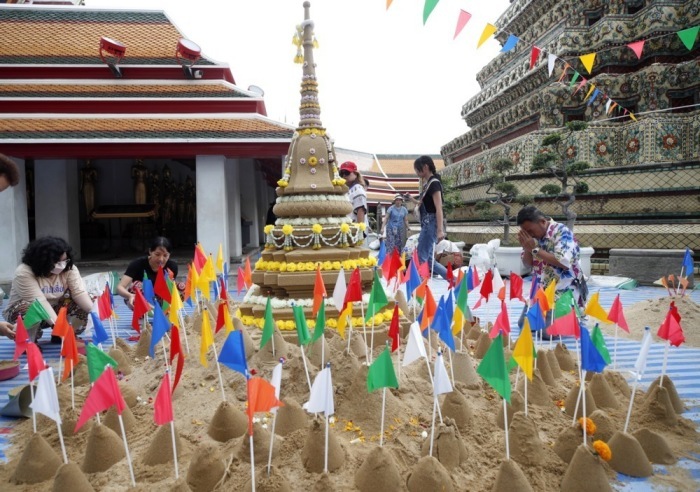 Besucher errichten beim Songkran-Fest symbolische Sand-Chedis als Teil religiöser Verdienstrituale in einem Tempelareal in Bangkok. Bild: epa/Rungroj Yongrit
