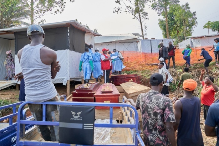 Angehörige von Ebola-Opfern warten vor einem Krankenhaus in Mongbwalu auf die Übergabe der Verstorbenen. Foto: EPA/Dieudonne Dirole