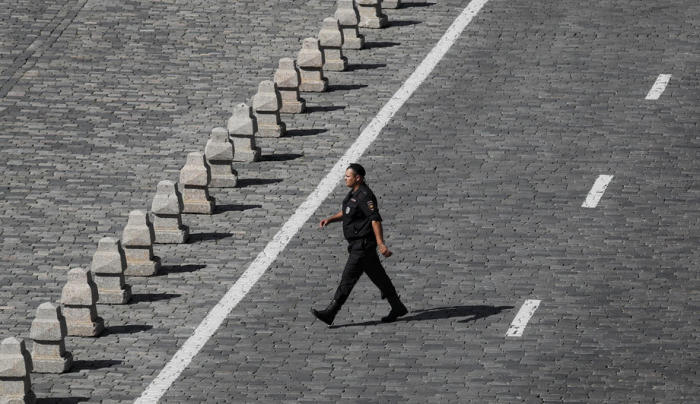 Eine Polizistin geht über das Kopfsteinpflaster in der Nähe des Roten Platzes in Moskau. Foto: epa/Yuri Kochetkov