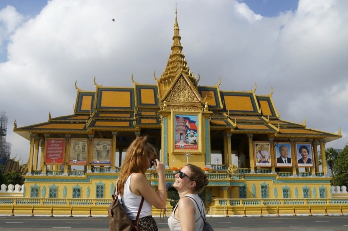 Touristen gehen an der Fassade des Königspalastes in Phnom Penh vorbei. Foto: EPA-EFE/Kith Serey