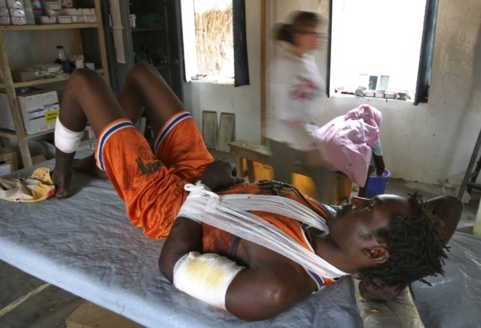 Ein Sudanese mit Schusswunden in der Klinik von Ärzte ohne Grenzen (MSF), während das Personal eifrig seiner Arbeit nachgeht. Foto: epa/Nic Bothma