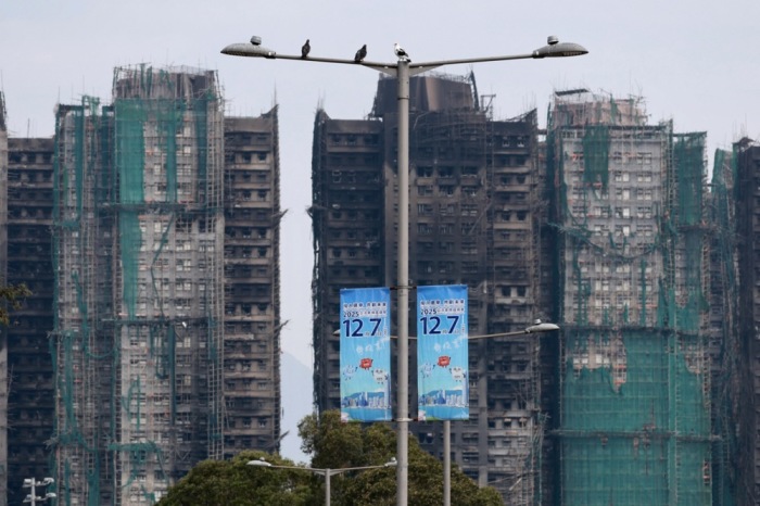 Ausgebrannte Gebäude in Tai Po stehen nahe einem Wahllokal, während Hongkong unter dem Eindruck eines tödlichen Wohnhausbrands das Parlament wählt. Archivfoto: epa/May James