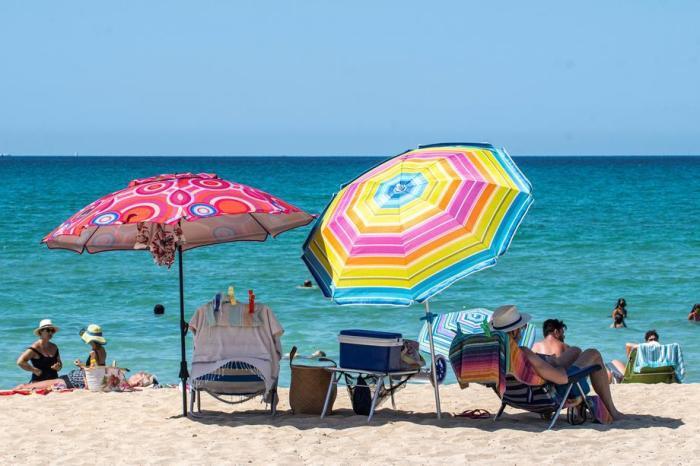 Die Leute genießen einen warmen Tag am Strand von Arenal in Palma de Mallorca. Foto: epa/Cati Cladera