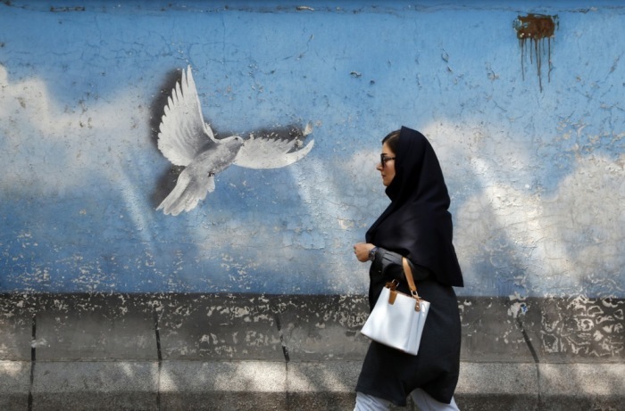 Die Frau geht an einem Wandgemälde mit einem Friedensvogel in Teheran vorbei. Foto: epa/Abedin Taherkenareh
