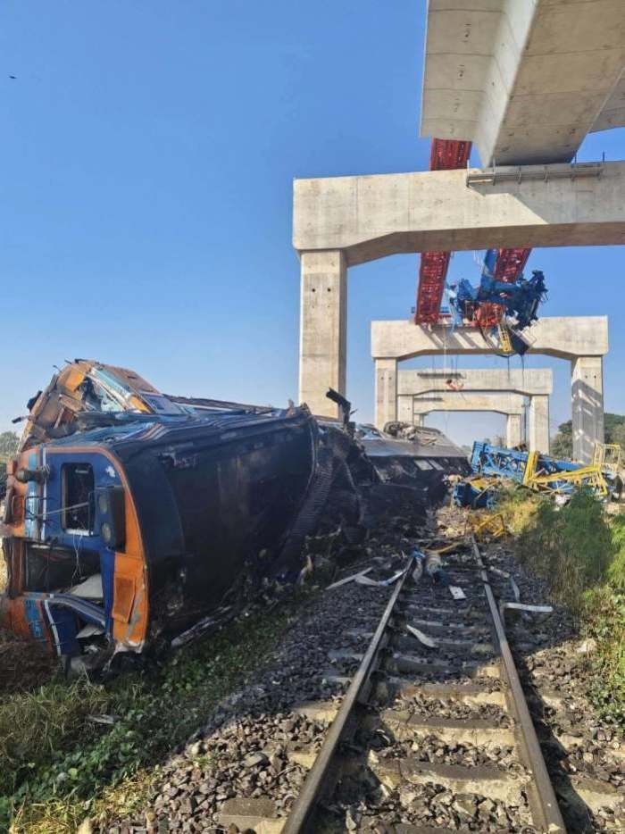 Der entgleiste Personenzug liegt nach der Kollision mit einem umgestürzten Baukran stark beschädigt auf den Gleisen. Foto: Fire & Rescue Thailand