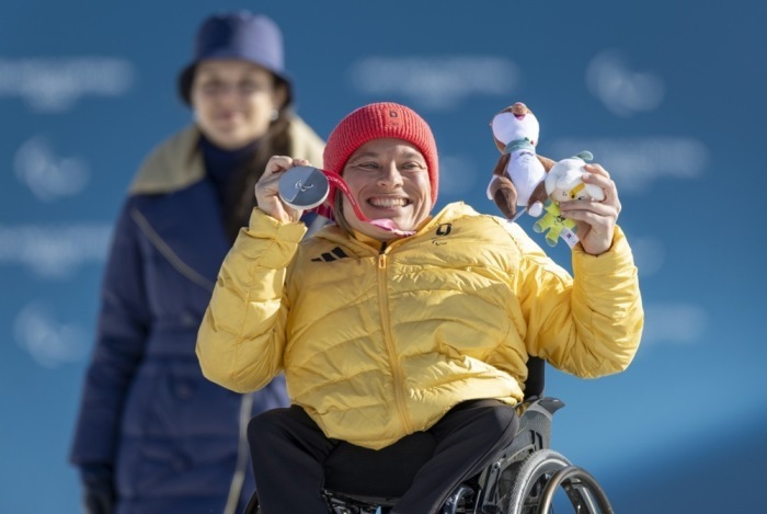 Anja Wicker GER feiert mit ihrer Silbermedaille auf dem Podium nach dem Para-Biathlon der Frauen im Sitzen im Langlaufstadion von Tesero bei den Paralympischen Winterspielen Milano Cortina 2026. Foto: epa/Davide Garbelli Für Ois
