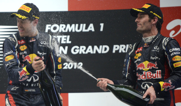 Der australische Formel-1-Pilot Mark Webber (R) von Red Bull Racing bespritzt seinen Teamkollegen, den deutschen Formel-1-Piloten Sebastian Vettel (L), nach dem Formel-1-Grand-Prix von Indien mit Champagner. Foto: epa/Franck Robichon