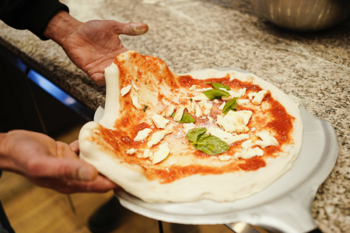Francesco Ialazzo, Weltmeister der Pizzabäcker, bereitet im Café Planken eine Pizza Margherita vor. Foto: Uwe Anspach/dpa