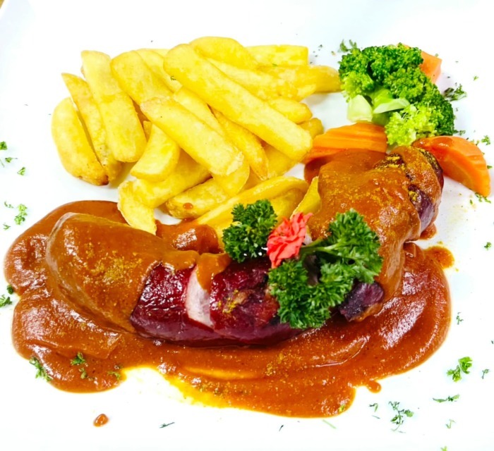 Die St. Galler Schüblig wird mit würziger Currysauce, Pommes frites und Gemüse serviert. Fotos: Jaybee'Swiss Restaurant