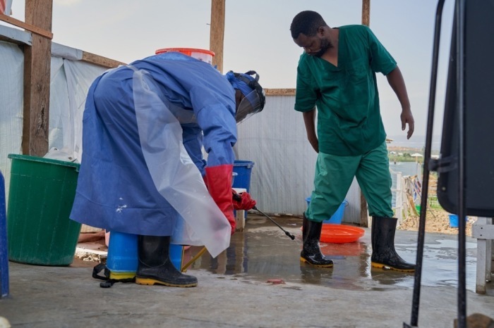 Ein Mitarbeiter des Ebola-Behandlungszentrums Rwampara in der Demokratischen Republik Kongo desinfiziert mit einem Sprühgerät die Einrichtung. Foto: EPA/Dieudonne Dirole