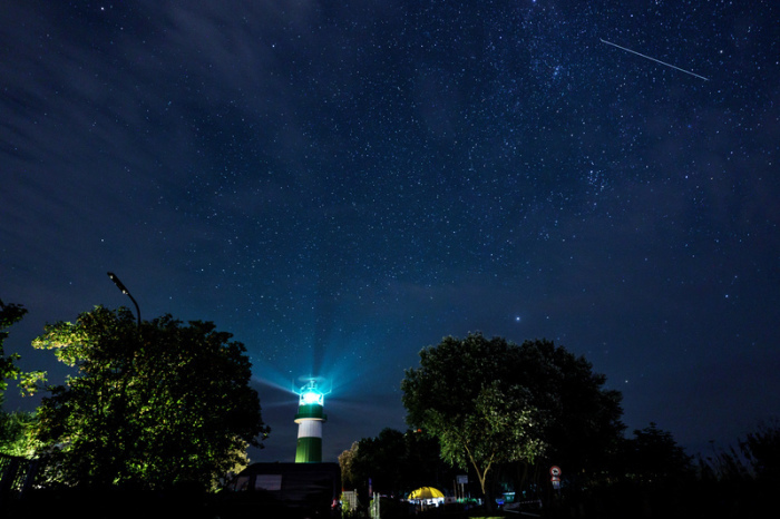 Eine Sternschnuppe zieht über dem Leuchtturm Bülk am Ufer der Ostsee ihre Bahn. Die Sternschnuppen der Perseiden sind in der ersten Augusthälfte teils im Minutentakt am Nachthimmel zu sehen. Foto: Axel Heimken/dpa