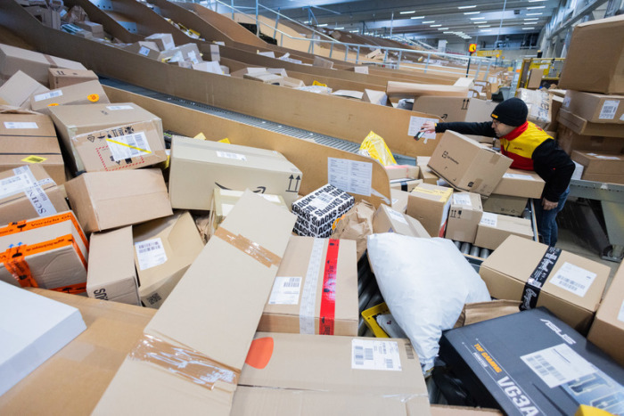 Ein Paketzusteller sortiert und räumt in einer Zustellbasis von Deutsche Post DHL Pakete in ein Zustellfahrzeug. Foto: Rolf Vennenbernd/dpa