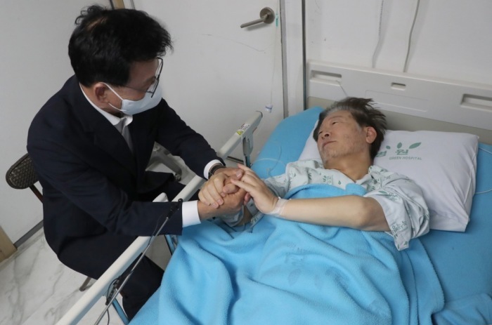 Park Kwang-on (L), Fraktionsvorsitzender der wichtigsten oppositionellen Demokratischen Partei, spricht mit dem Parteivorsitzenden Lee Jae-myung (R) in einem Krankenhaus in Seoul. Foto: epa/Yonhap
