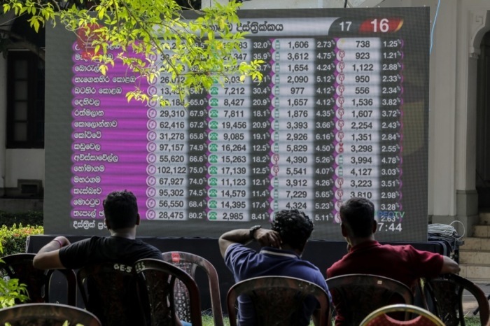 Menschen betrachten die Wahlergebnisse, die am Tag nach der Parlamentswahl in Colombo auf einem riesigen Bildschirm in einem Auszählungszentrum angezeigt werden. Foto: epa/Chamila Karunarathne