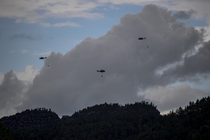 Hubschrauber im Einsatz bei Waldbrand nahe Bad Schandau an der deutsch-tschechischen Grenze, wo Feuerwehrkräfte gegen die Flammen kämpfen. Archivfoto: epa/Martin Divisek