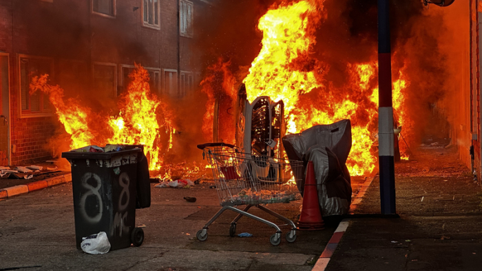 Fahrzeuge, die von Demonstranten in der Lendrick Street in Belfast in Brand gesetzt wurden, während Unruhen nach einem Messerangriff am Montagabend in der Stadt aufflammten. Foto: Pa/Pa Wire/dpa