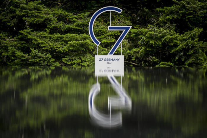 Auf Schloss Elmau in Krün spiegelt sich das Logo des G7-Gipfels in einem Teich. Foto: epa/Christian Bruna