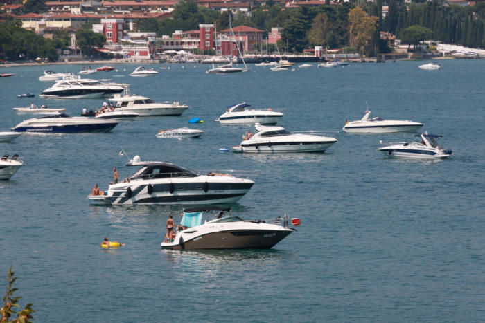 Leute auf Yachten genießen einen sonnigen Sommertag auf dem Gardasee in Desenzano del Garda. Foto: epa/Filippo Venezia