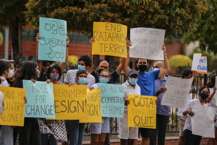 Menschen protestieren an einem Straßenrand in Colombo gegen die aktuelle Wirtschaftskrise. Foto: epa/Chamila Karunarathne