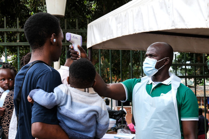 Ein Gesundheitsbeamter kontrolliert Menschen vor einem Krankenhaus in Kampala nach dem Ebola-Ausbruch in Uganda und im Kongo. Foto: AP/Hajarah Nalwadda