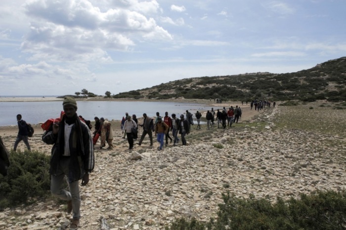 Migranten spazieren am Strand von Tripiti auf der Insel Gavdos. Foto: epa/Vassilis Mathioudakis