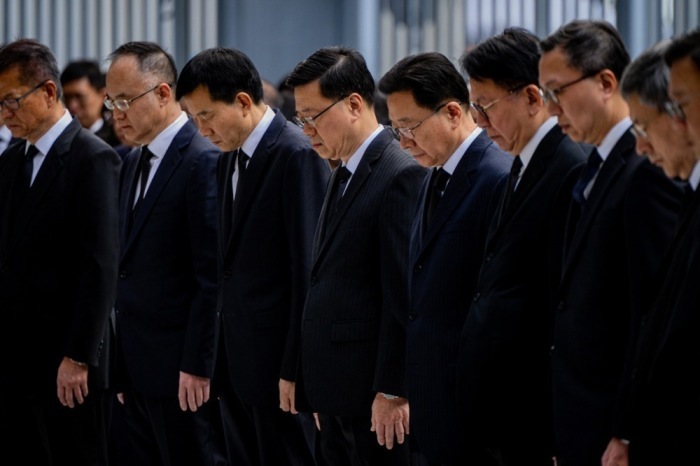 Hongkongs Regierungschef John Lee und Beamte halten eine Schweigeminute, während die Flaggen für die Opfer des Feuers in Tai Po auf Halbmast stehen. Foto: EPA/Leung Man Hei