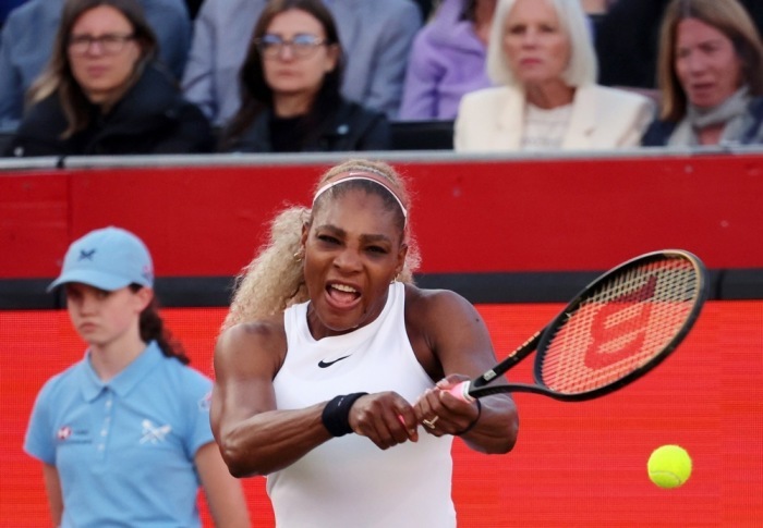 Serena Williams schlägt bei ihrem Doppelmatch im Queen’s Club in London den Ball, während ihre Partnerin Victoria Mboko zusieht. Foto: epa/Andy Rain