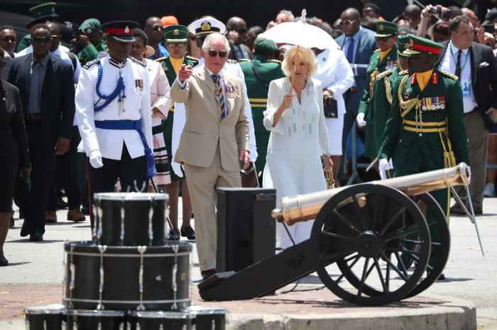 Charles (M), Prinz von Wales, und seine Frau Camilla, Herzogin von Cornwall, nehmen an einer Begrüßungszeremonie bei ihrer Ankunft am Heroes Square im Rahmen ihrer Tour durch die Karibik teil. Foto: Jane Barlow