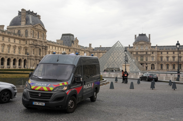 Ein Polizeiwagen patrouilliert im Hof des nach einem Raubüberfall geschlossenen Louvre, während Ermittler weitere Tatverdächtige fassen. Foto: AP/Thibault Camus