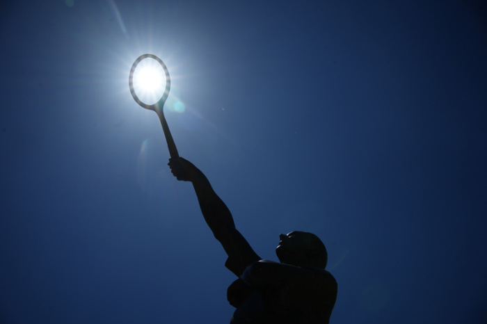 Die Sonne scheint über der Statue der französischen Tennislegende Jean Borotra während des French Open Tennisturniers. Foto: Christophe Ena/Ap/dpa
