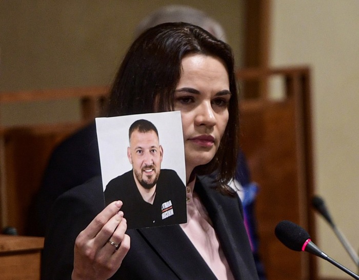Swetlana Tichanowskaja zeigt 2021 im tschechischen Senat ein Bild ihres damals inhaftierten Mannes Sergej Tichanowski. Foto: epa/Roman Vondrous