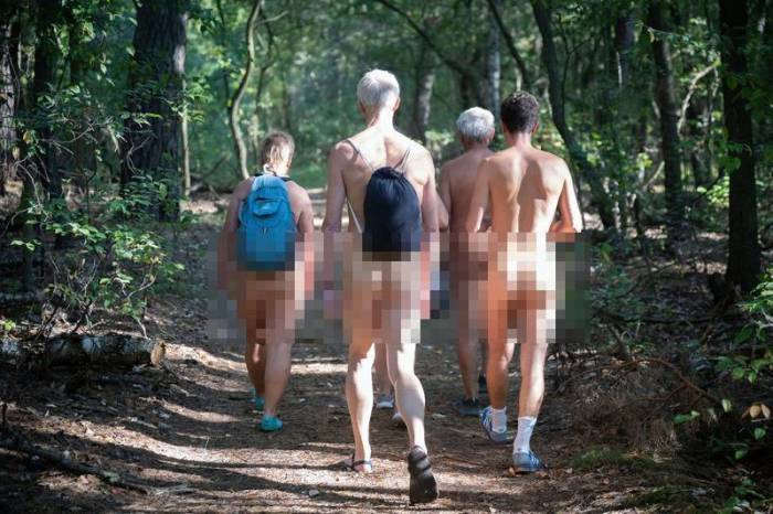 Nackte Wanderer laufen auf dem Naturwanderweg am Rätzsee. Foto: Philip Dulian/dpa