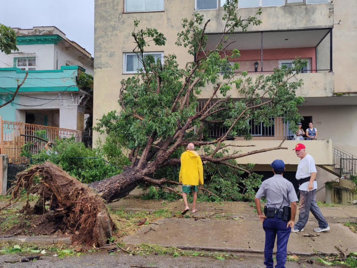 In Havanna betrachten Menschen einen umgestürzten Baum nach dem Durchzug des Hurrikans Ian. Foto: epa/Juan Palop