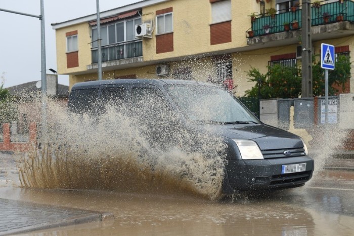 Ein Auto fährt durch aufgestautes Wasser in einer Straße in Villamanta, Madrid. Foto: Gustavo Valiente/Europa Press/dpa