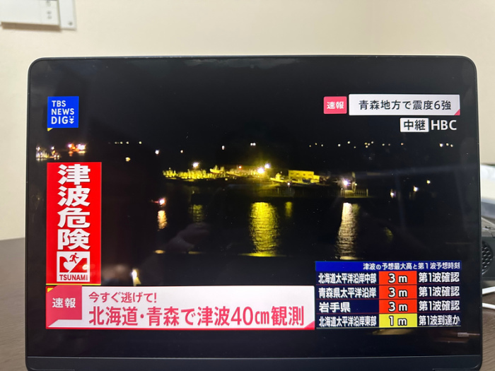 Ein Bildschirm zeigt Bebenwarnungen, nachdem ein Erdbeben den Nordosten Japans erschüttert und eine Tsunamiwarnung ausgelöst hat. DaFoto: dpa/Li Ziyue