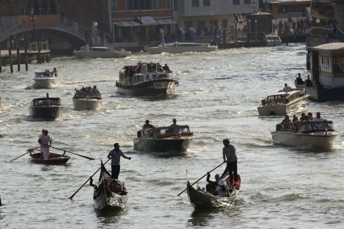 Boote und Gondeln fahren auf einem Kanal. Foto: Luca Bruno/Ap/dpa