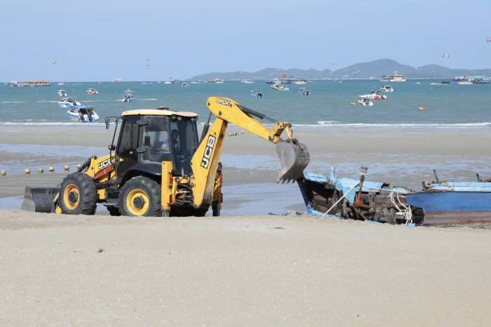 Ein Bagger beginnt am Strand von Nord-Pattaya mit der Zerlegung des bei einem Sturm gesunkenen Boots. Bild: TMN.TV