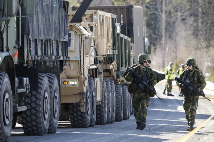 Die schwedischen Soldaten gehen neben einer Kolonne von Fahrzeugen des U.S. Marine Corps. Foto: epa/Pontus Lundahl Schweden Out