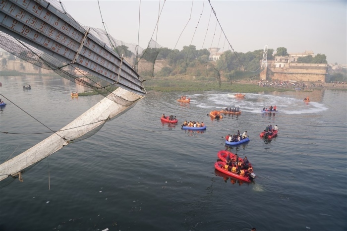 Polizisten und Militärangehörige der National Disaster Response Force (NDRF) arbeiten an der Stelle, an der eine 100 Jahre alte Hängebrücke in Morbi, Gujarat, zusammengebrochen ist. Foto: epa/Siddharaj Solanki