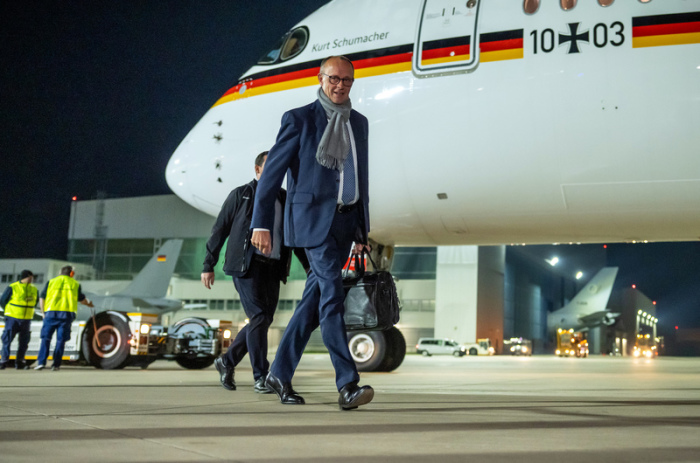 Bundeskanzler Friedrich Merz (r, CDU) steigt in ein Flugzeug der Flugbereitschaft der Luftwaffe, um zum G20-Gipfel nach Johannesburg in Südafrika zu fliegen. Am Sonntag bricht Merz nach Indien auf - die erste größere... Foto: Michael Kappeler/dpa