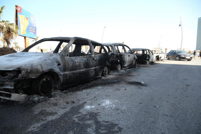 Beschädigte Fahrzeuge nach nächtlichen Zusammenstößen zwischen loyalen Kämpfern der Regierung in Tripolis und der Regierung in Tobruk in Tripolis. Foto: epa/Str