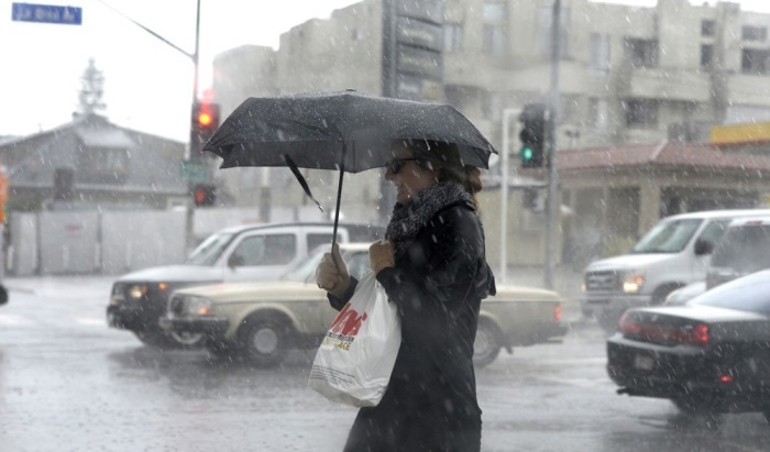 Ein Frau trotzt einem Regenschauer, während sie die La Brea Avenue in Los Angeles entlangläuft. Archivfoto: epa/MIKE NELSON