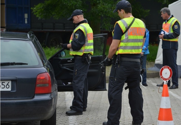 Beamte der Bundespolizei kontrollieren die Insassen eines PKWs auf einem Parkplatz an der Autobahn A 64 in der Nähe von Trier. Foto: epa/Harald Tittel