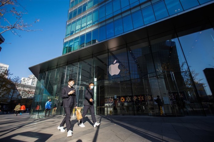 Leute mit Gesichtsmasken laufen an einem Apple Store in einem Einkaufszentrum in Peking vorbei. Foto: epa/Wu Hao