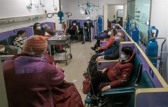 Menschen, die eine intravenöse Therapie und Sauerstofftherapie erhalten, sitzen am 13. Januar 2023 in einem Korridor eines Krankenhauses in Shanghai. Foto: EPA-EFE/Alex Plavevski