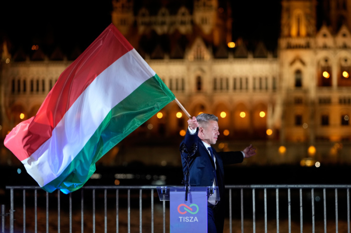 Peter Magyar, der Vorsitzende der Oppositionspartei Tisza, schwenkt nach der Parlamentswahl eine Nationalflagge. Foto: Darko Bandic/Ap/dpa
